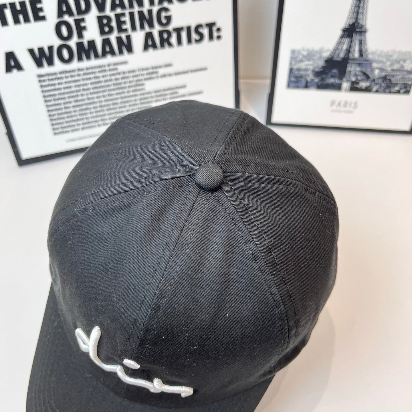 Dior black cap back view with small round button on the crown.