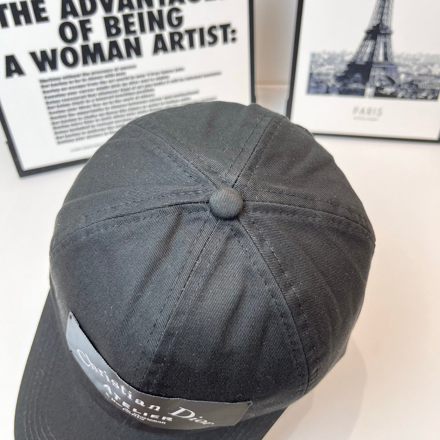 Dark gray baseball cap top button and side Dior patch label.