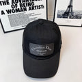 Black baseball cap with Christian Dior Atelier front patch and small top button.