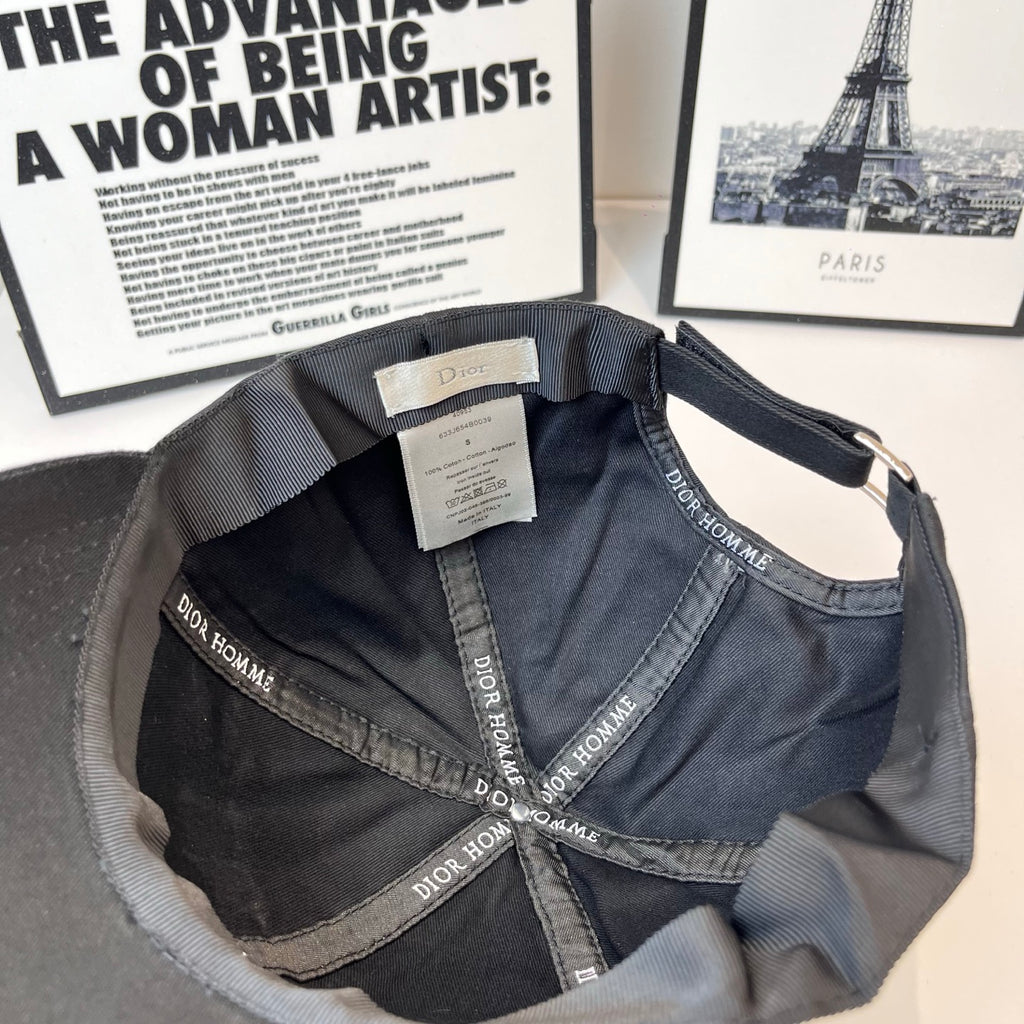 Navy-blue cap interior with Dior Homme printed straps and small care label.