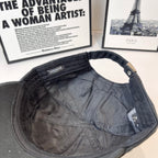 Dark baseball cap interior showing lining and stitched strap panel with tag.