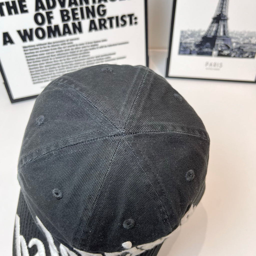 Dark baseball cap back view with stitched crown panels and small ventilation eyelets.