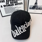 Balenciaga cap in dark fabric with white embroidered “balenciaga” logo on the front