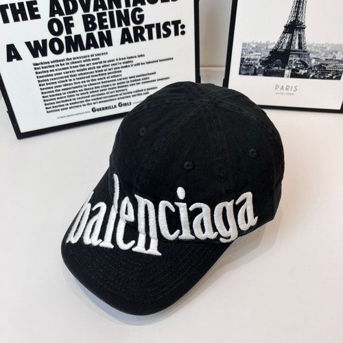 Balenciaga cap with white embroidered “balenciaga” script across the front, dark fabric