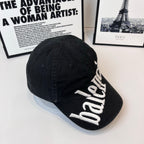 Balenciaga cap with white embroidered “balenciaga” logo on the brim edge, dark fabric