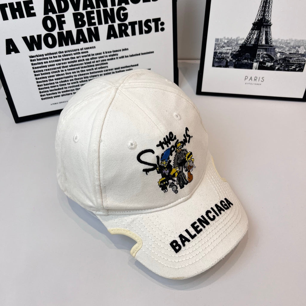 White Balenciaga cap angled view with embroidered cartoon patch and BALENCIAGA logo