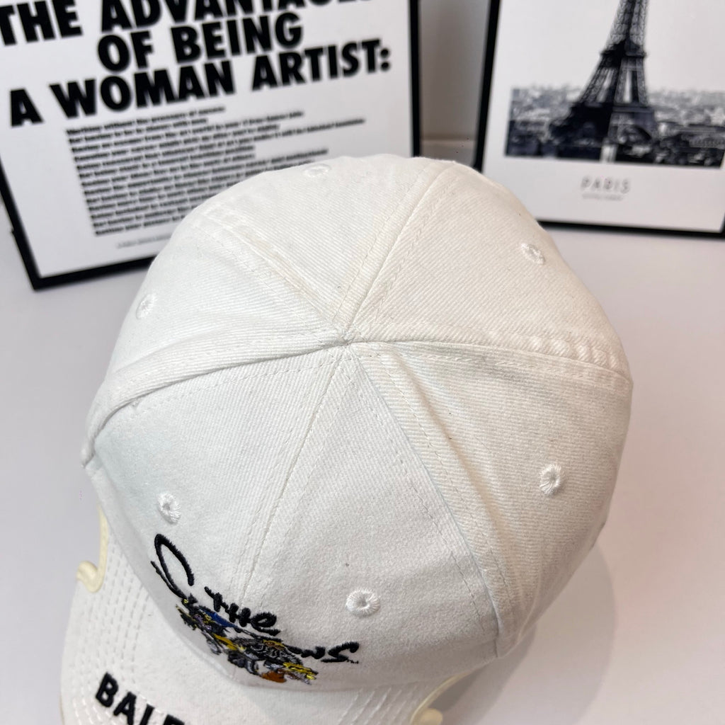 White Balenciaga cap top view with metal eyelets and partial embroidered patch