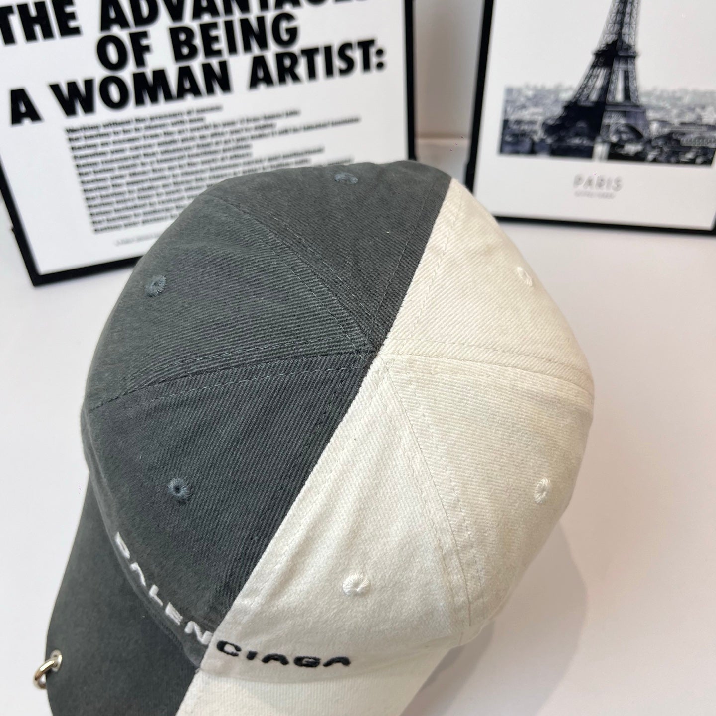Two-tone baseball cap with BALENCIAGA logo, dark gray side panels and cream back.