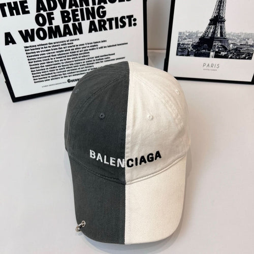 Two-tone baseball cap, dark gray and off-white, BALENCIAGA logo on front.