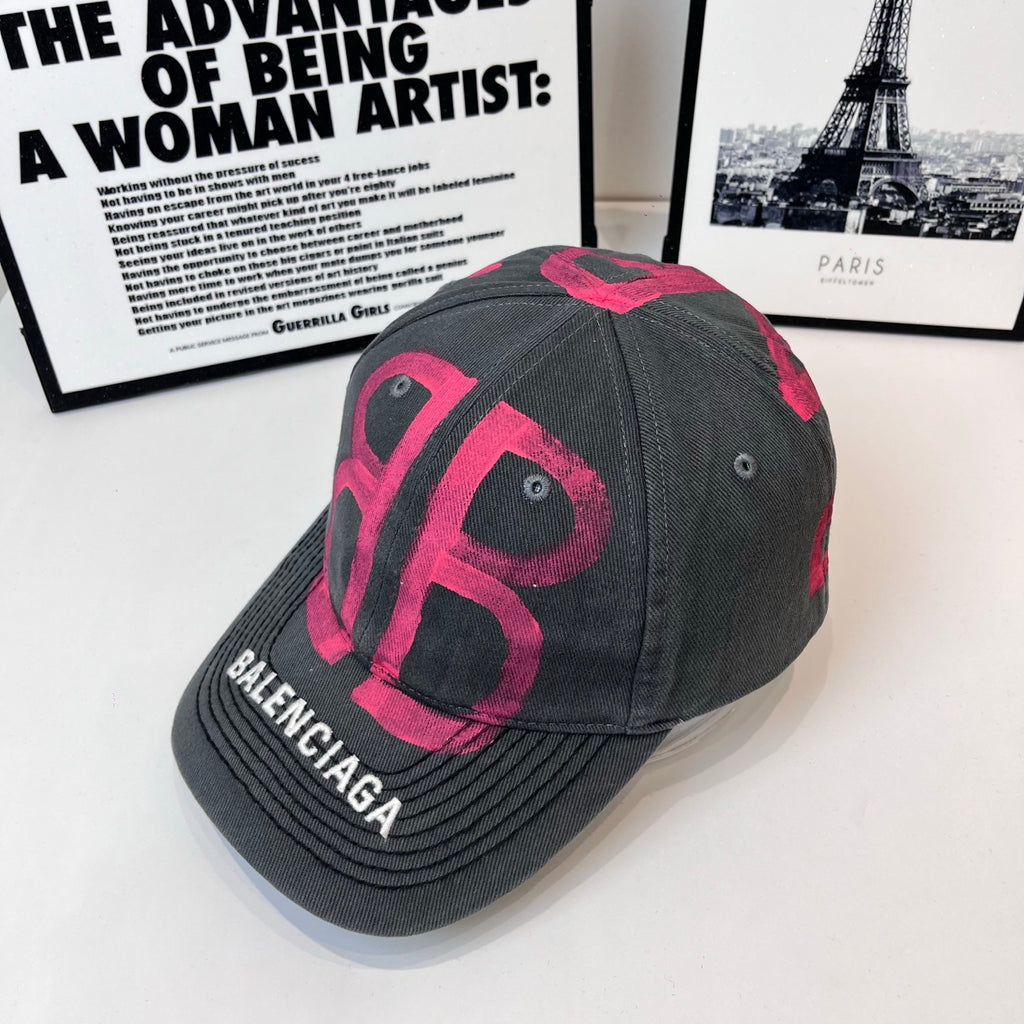 Baseball cap, dark gray with pink logo lettering and BALENCIAGA on curved brim.