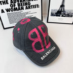 Baseball cap, dark gray with pink monogram graphic and BALENCIAGA on side panel.