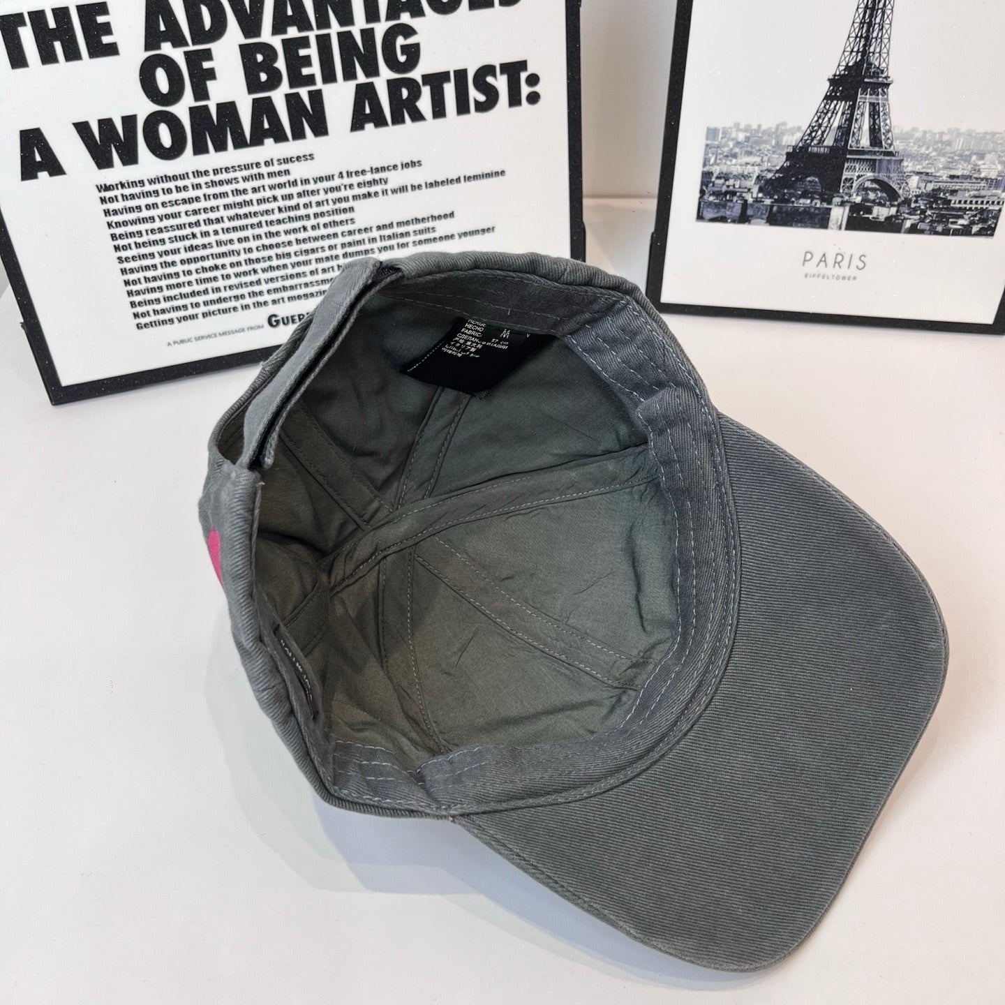 Baseball cap interior view, dark gray fabric lining and small label at top.