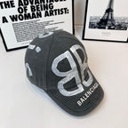 Balenciaga cap, dark gray, 3/4 view with oversized silver monogram logo