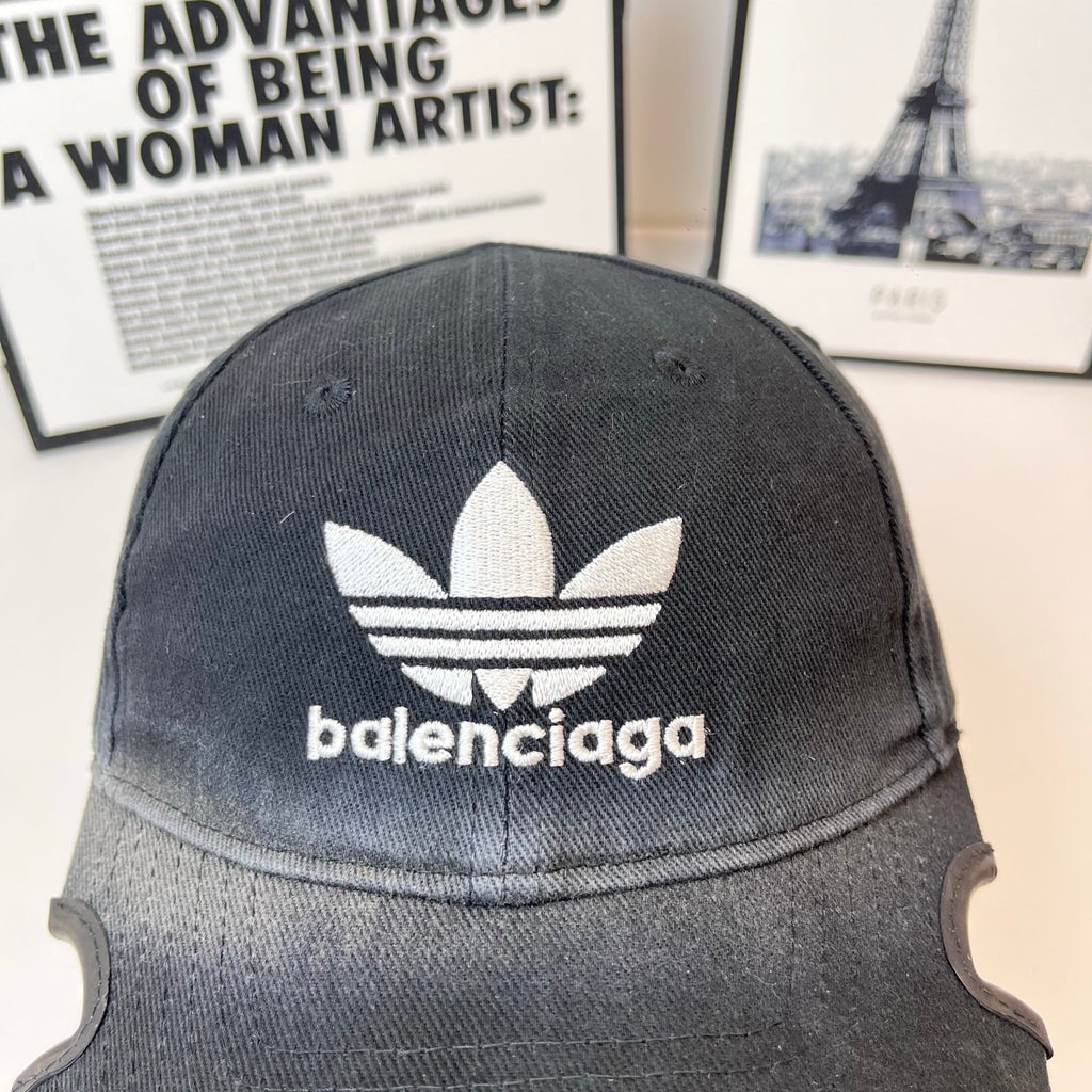 Balenciaga baseball cap close-up, dark fabric with white trefoil logo