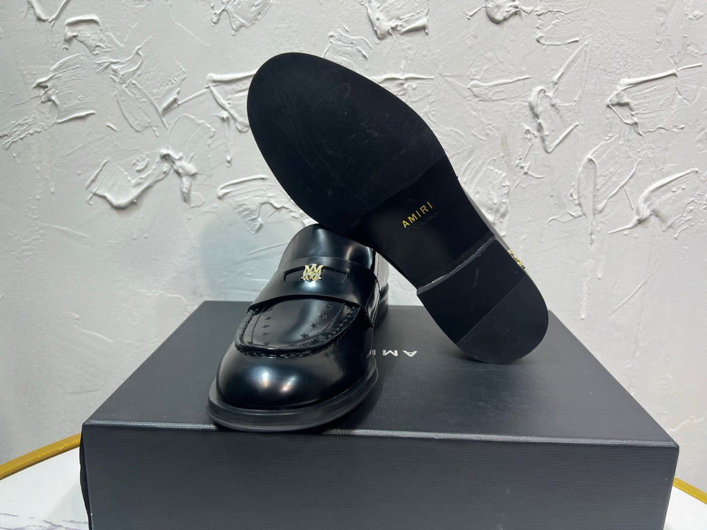 Amiri black leather loafer shoe with gold emblem, shown with outsole and upper