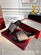 Gucci monogram slide sandals with GG canvas upper and dark rubber footbed