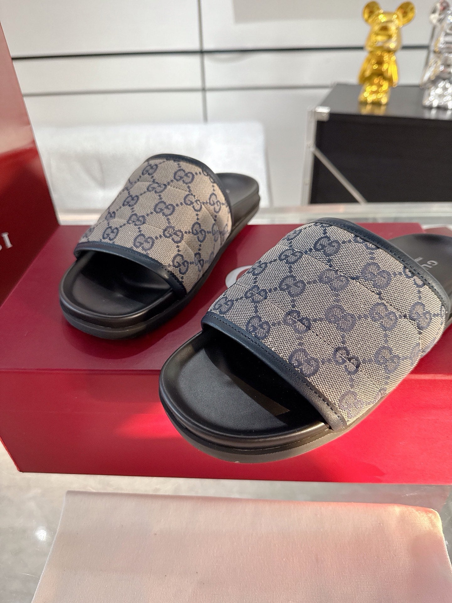 Gucci GG logo slide sandals with beige patterned straps and black soles