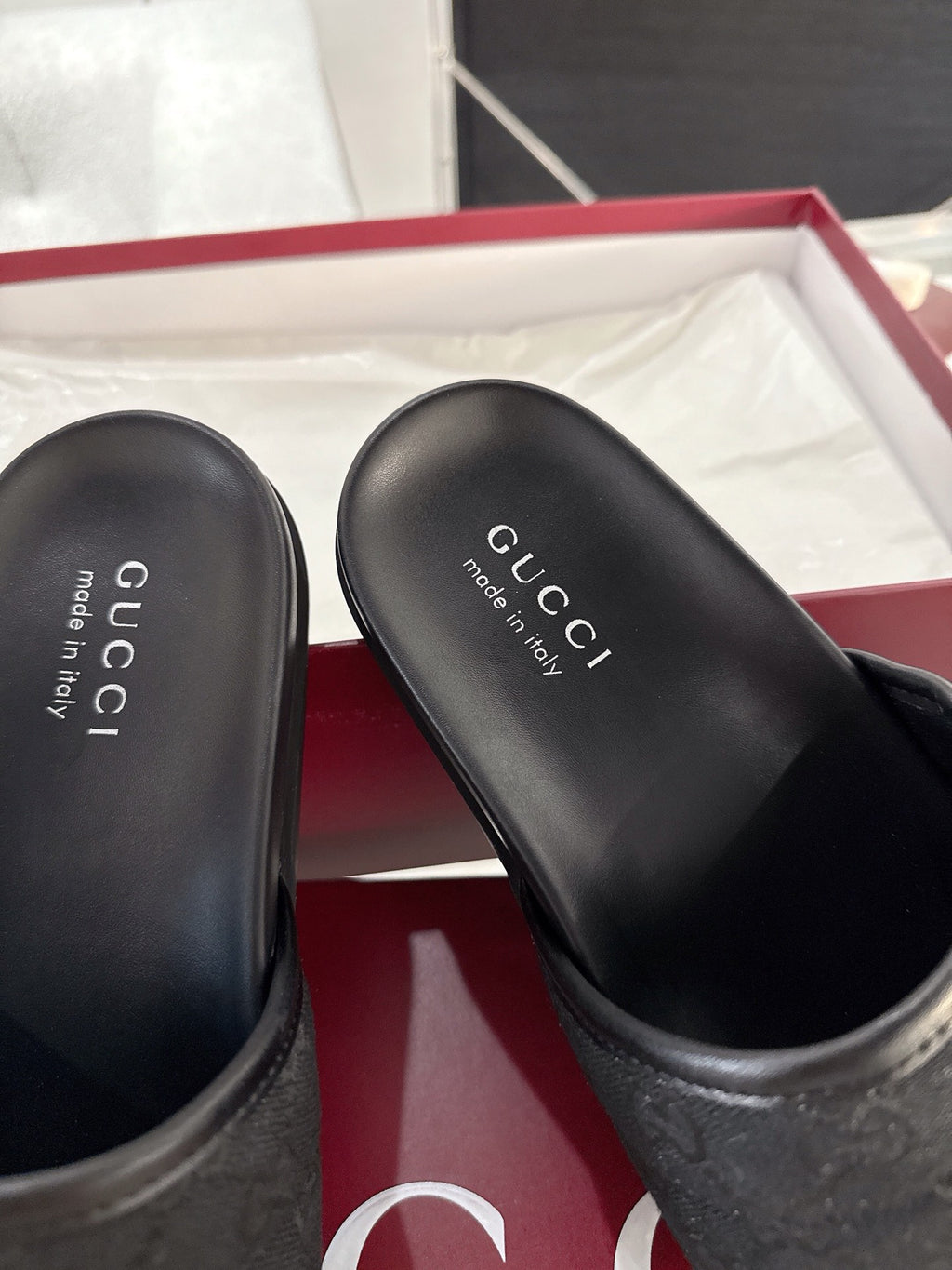 Gucci black slide sandal close-up of footbed with Gucci logo text