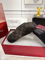 Gucci black slide sandals close-up of monogram thong-style footbed on red box