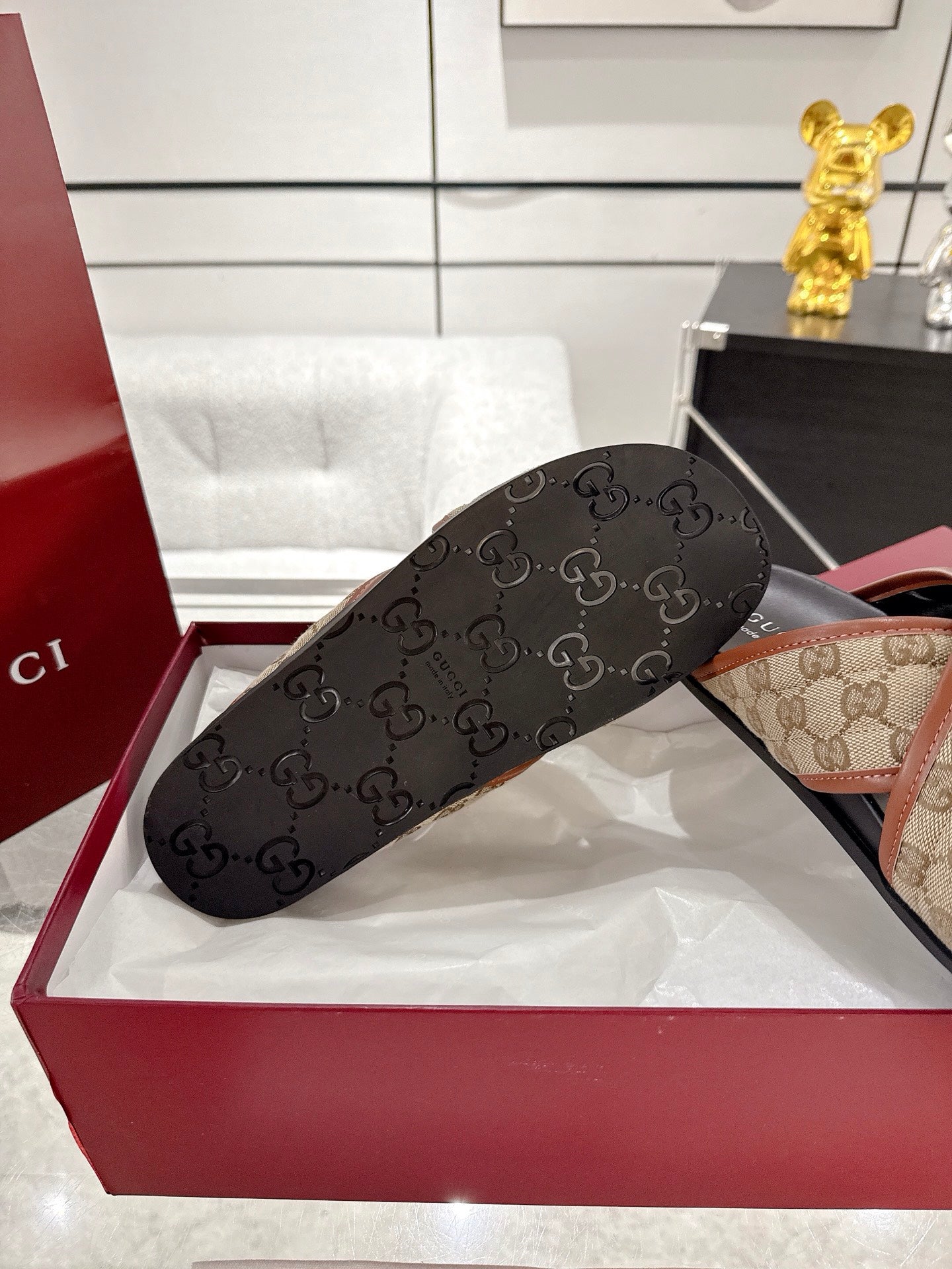 Gucci slide sandals close-up: black monogram strap with beige leather-lined edge