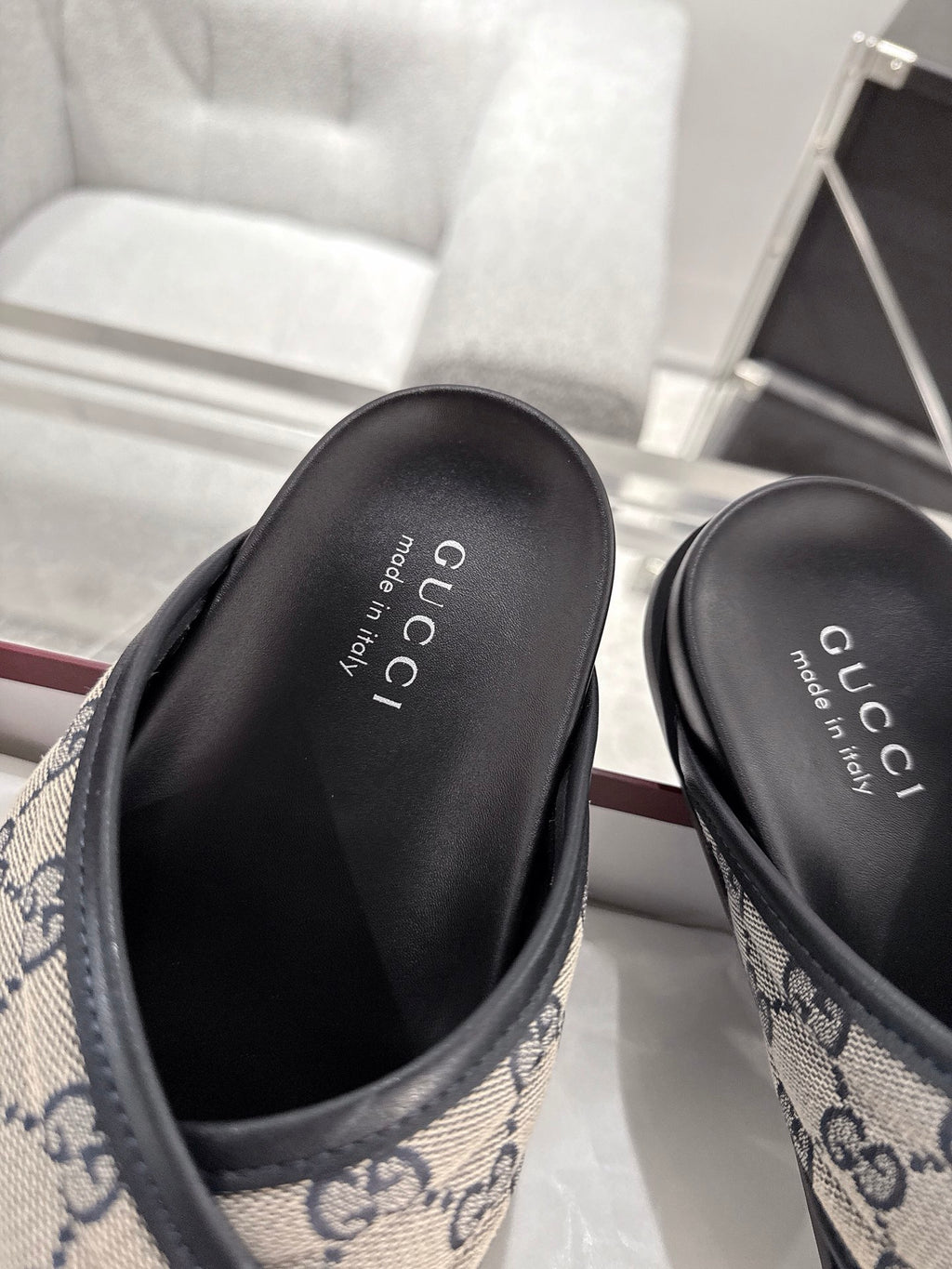 Gucci slide sandals close-up of black leather footbeds with blue GG trim