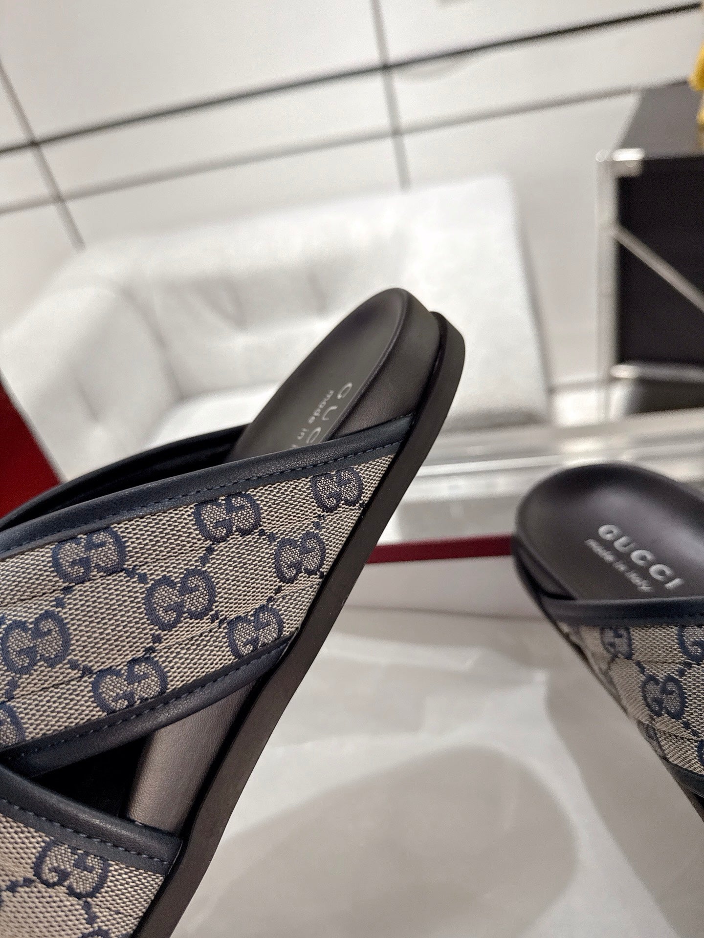 Gucci slide sandal close-up of blue GG canvas strap and black footbed