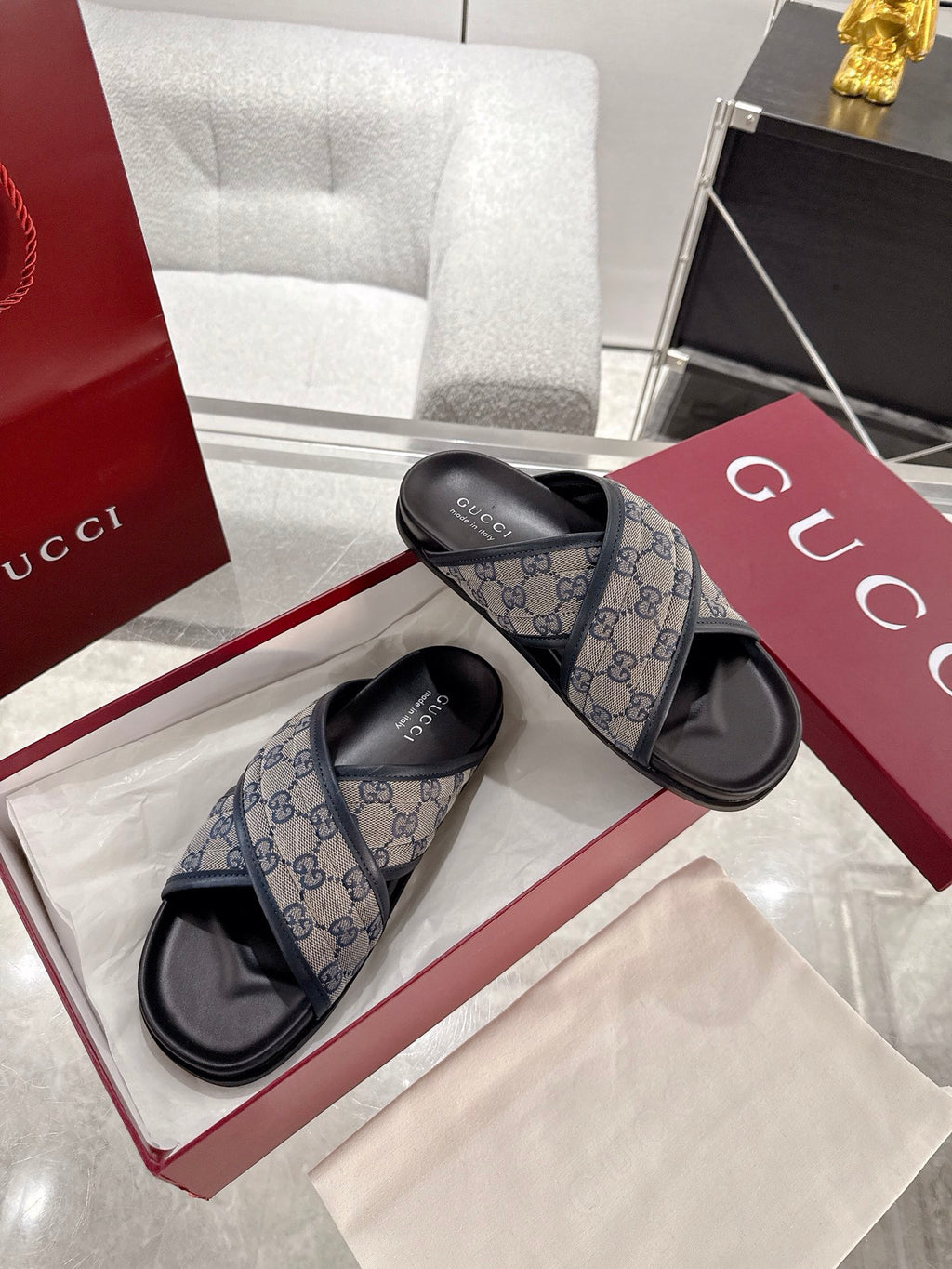 Gucci slide sandals in blue GG canvas with black rubber soles on display