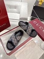 Gucci slide sandals in blue GG canvas with black rubber soles on display