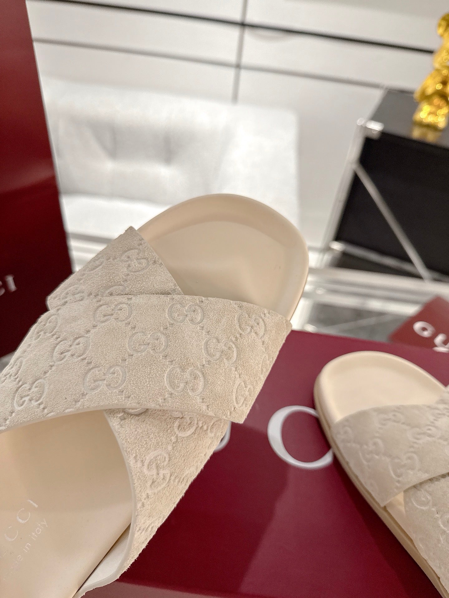 Cream Gucci slide sandals with logo-style strap pattern and open toe