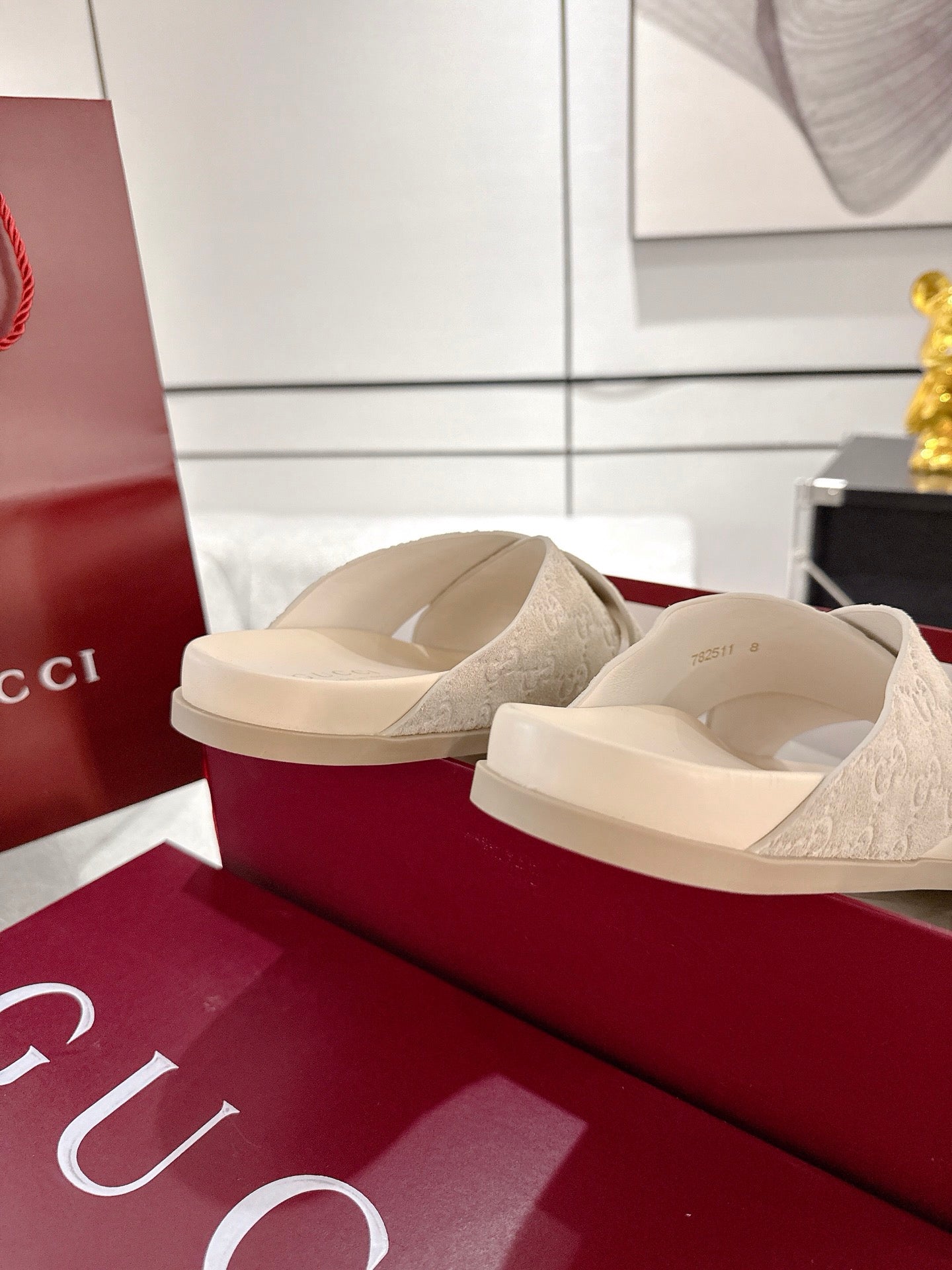 Cream Gucci slide sandals showing side view and cushioned strap texture