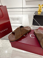 Gucci brown GG slide sandals with open toe crossover strap, shown on red box