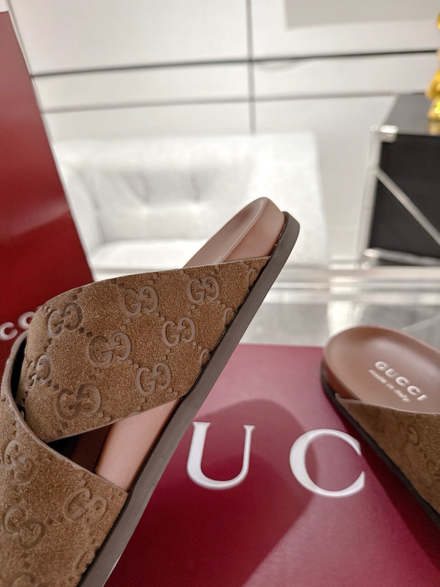 Gucci GG slide sandals close-up, brown upper with open toe and crossover strap
