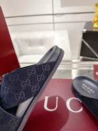 Gucci slide sandals with dark blue GG logo strap and molded rubber outsole