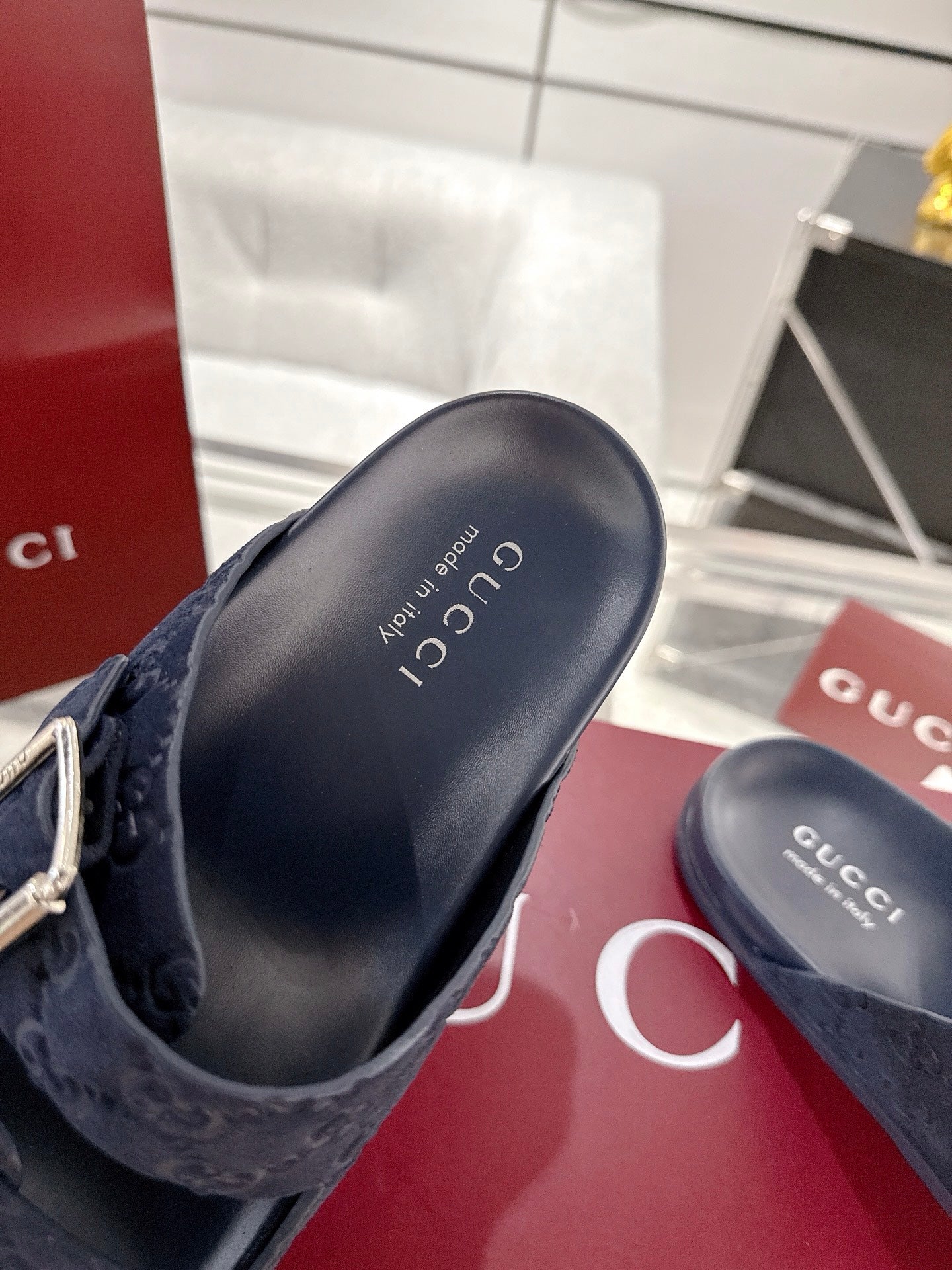 Navy Gucci slide sandals, open toe, showing cushioned footbed and GG pattern