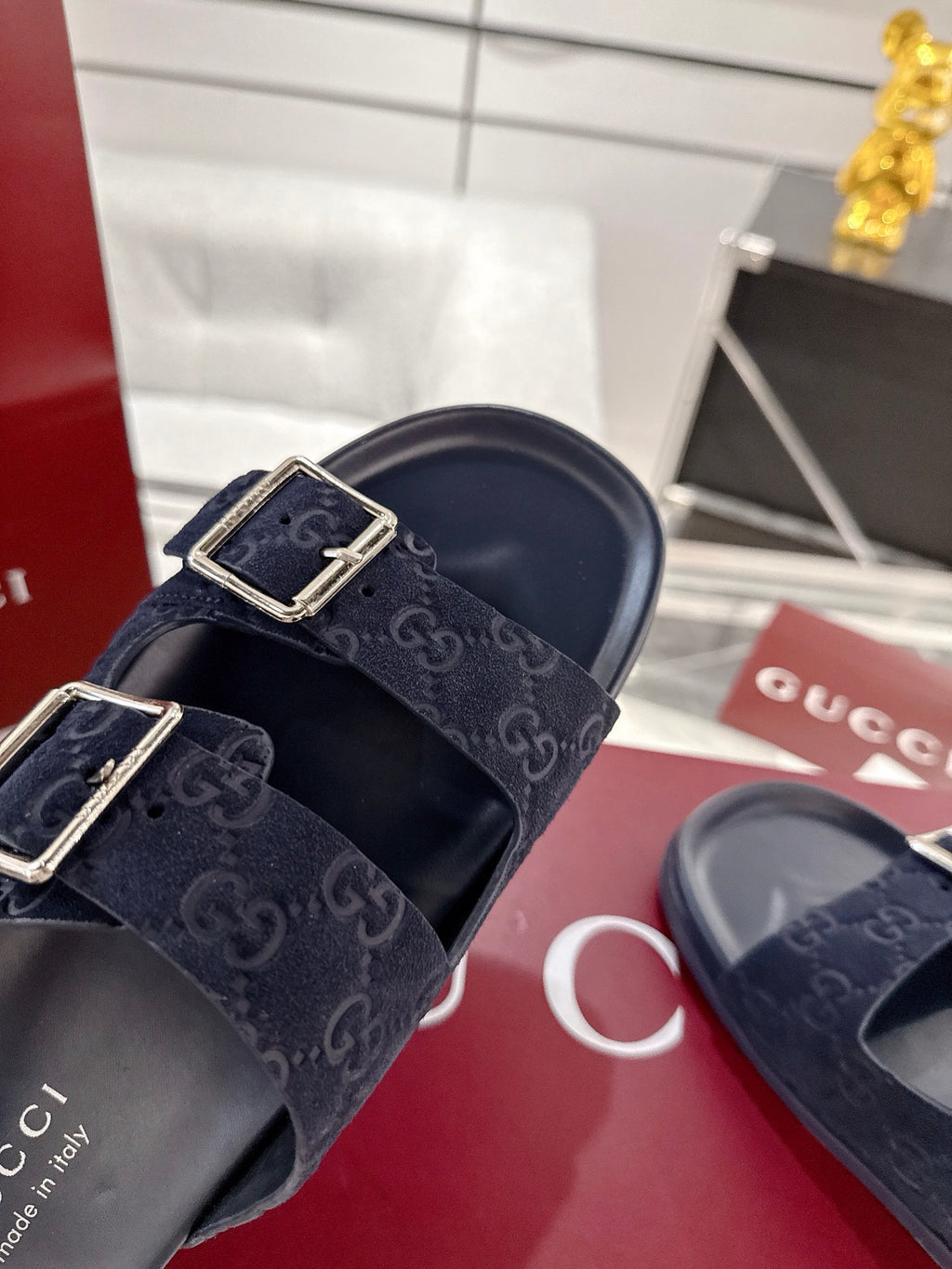 Navy Gucci double-buckle slide sandals with GG monogram straps, close-up