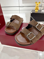 Brown logo-print slide sandals with two silver-tone buckles, shown side by side