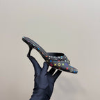 Louis Vuitton women's mule heel held in hand, multicolor logo print on black
