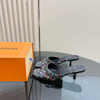 Louis Vuitton women's mule heels in black with multicolor logo pattern, side view