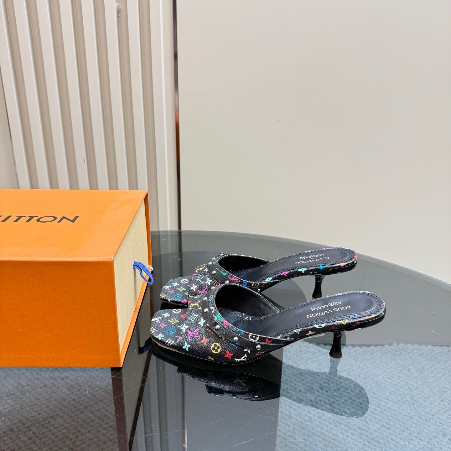Louis Vuitton women's mule heels in black with multicolor logo pattern, side view