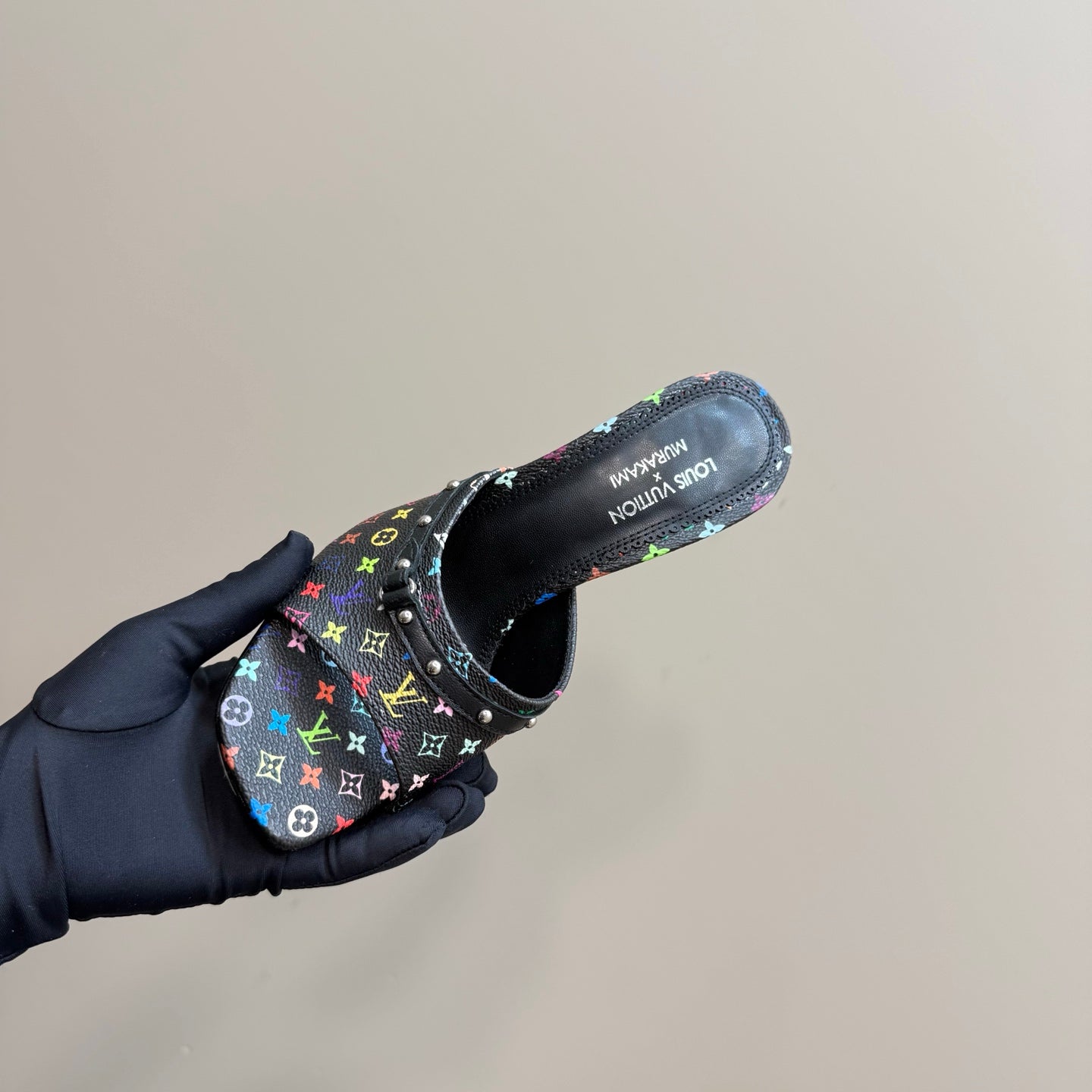 Louis Vuitton heeled mule on hand, top view of black multicolor monogram upper and open collar