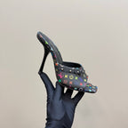 Louis Vuitton heeled mule on hand, side view of black multicolor monogram upper and heel