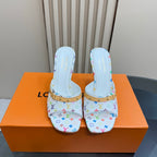 Light blue patterned mule heels with gold-trim straps and white stiletto heel