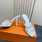 Light blue patterned mule heels with gold-studded strap and white stiletto heel