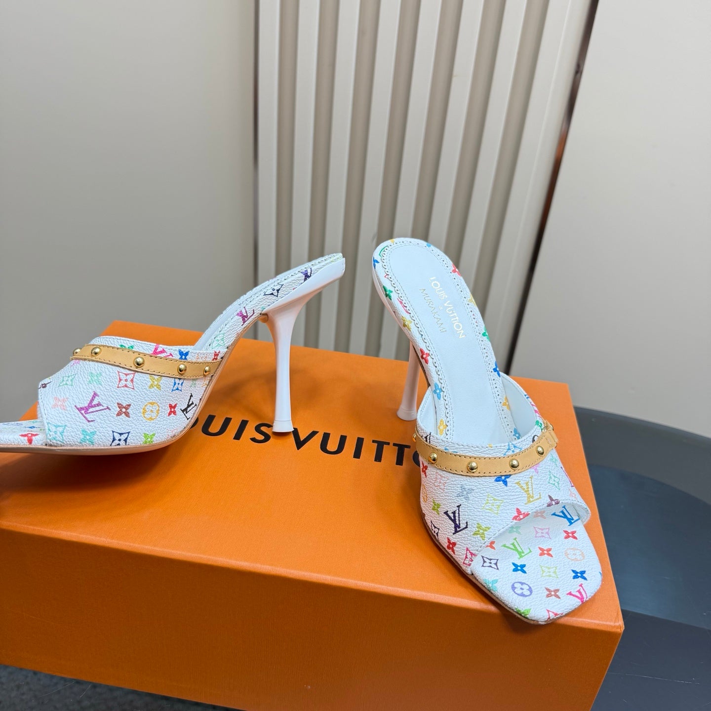 Light blue patterned mule heels with gold-studded strap and white stiletto heel