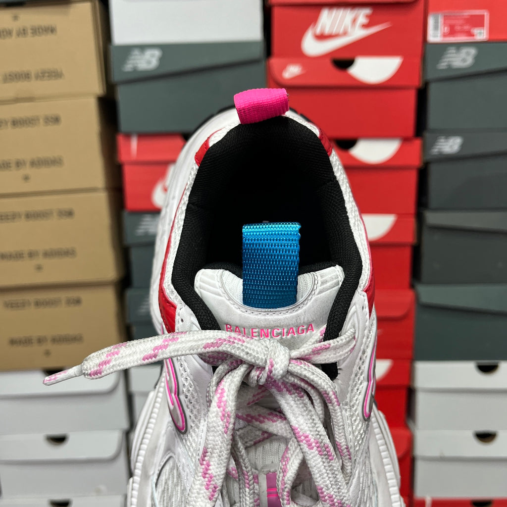 Unisex sneaker heel view with pink pull tab, blue collar strap, and knit lining.