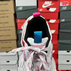 Unisex sneaker heel view with pink pull tab, blue collar strap, and knit lining.