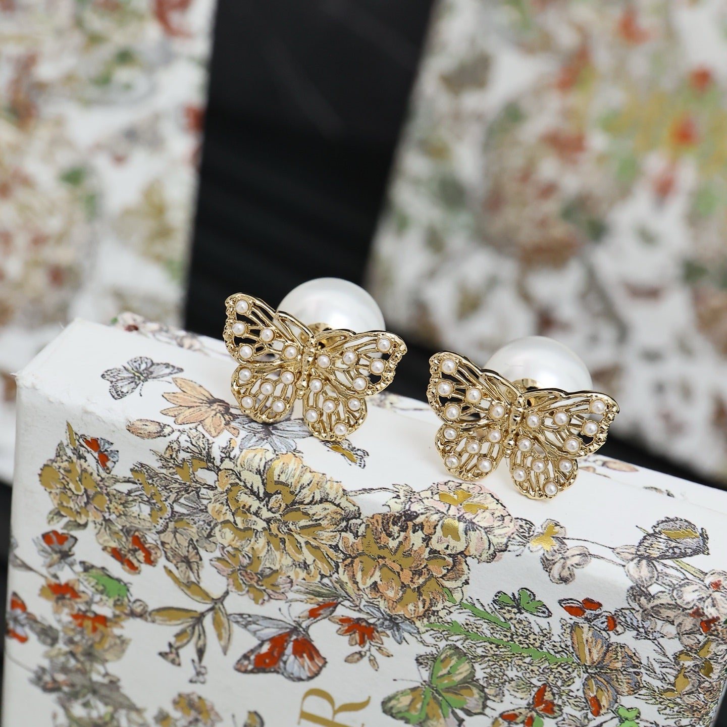 Gold butterfly earrings with white pearls and detailed crystal embellishment