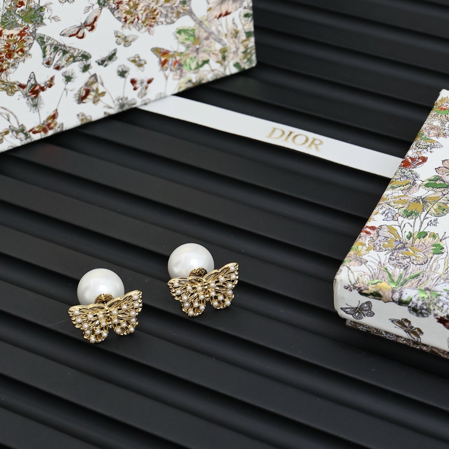 Gold butterfly earrings with white pearl studs and textured filigree