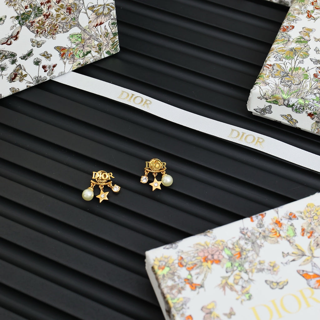 Dior gold-tone star and pearl stud earrings on black ridged card