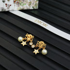 Dior gold-tone drop earrings with pearl, star, and rhinestone accents